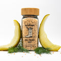 Salt jar with wooden lid and label. Dill pickle spears and dill fronds arranged around jar.
