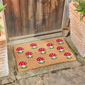 Coir doormat printed with a cluster of toadstools and a welcome message, shown flat from above