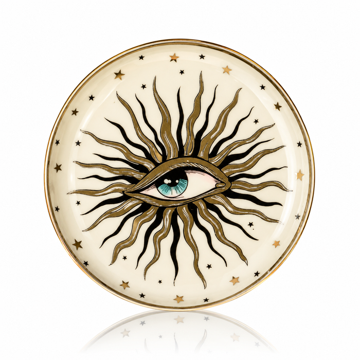 A round decorative plate featuring an all-seeing eye design with radiating black and gold rays, gold stars, and a gold rim on a white background.