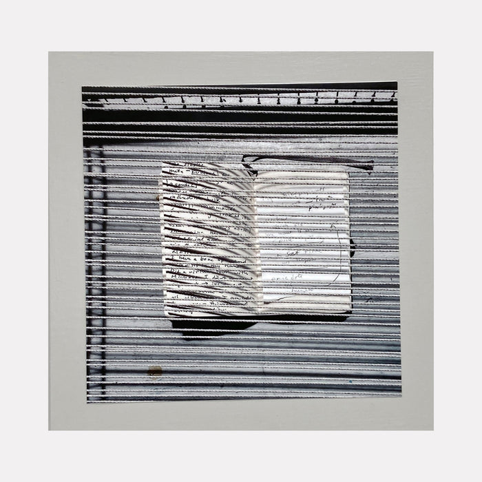 The artwork 'Sentence Structure String 1' by Anne Sherwood Pundyk features a monochromatic composition with parallel horizontal lines creating a textured background. A central white rectangular form emerges, marked with abstract linear notations resembling text or musical notation. The piece combines stark black and white contrast in an archival inkjet print mounted on wood panel.