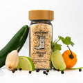 Jar of tequila salt with assorted veggies and herbs scattered around.
